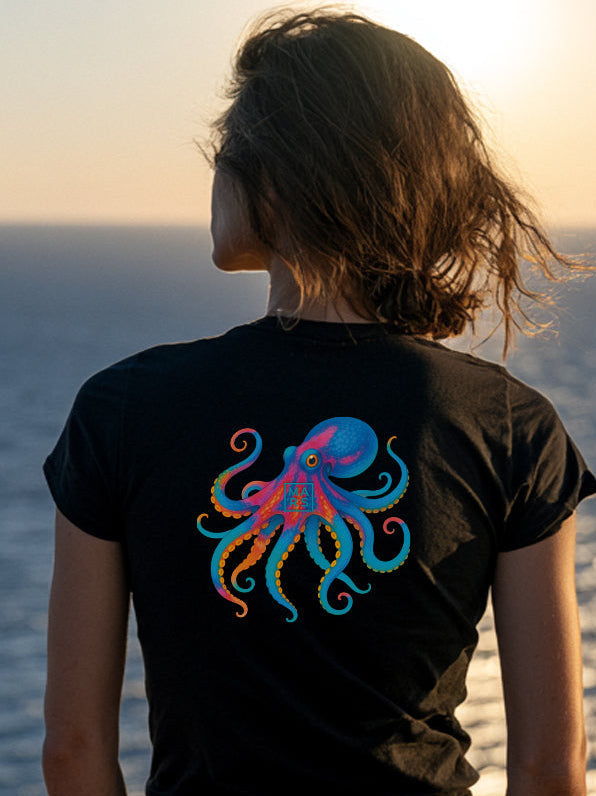 Une jeune femme au bord de la mer portant un tee-shirt noir avec un joli motif de poulpe
