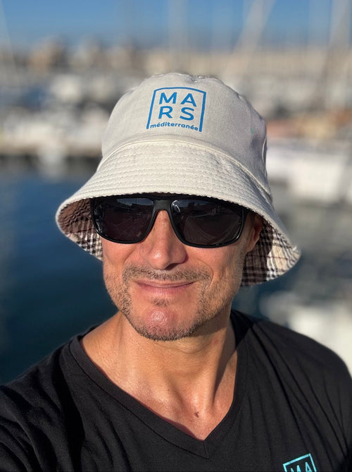 Jeune homme avec un bob, très tendance, avec un logo MARS en bleu