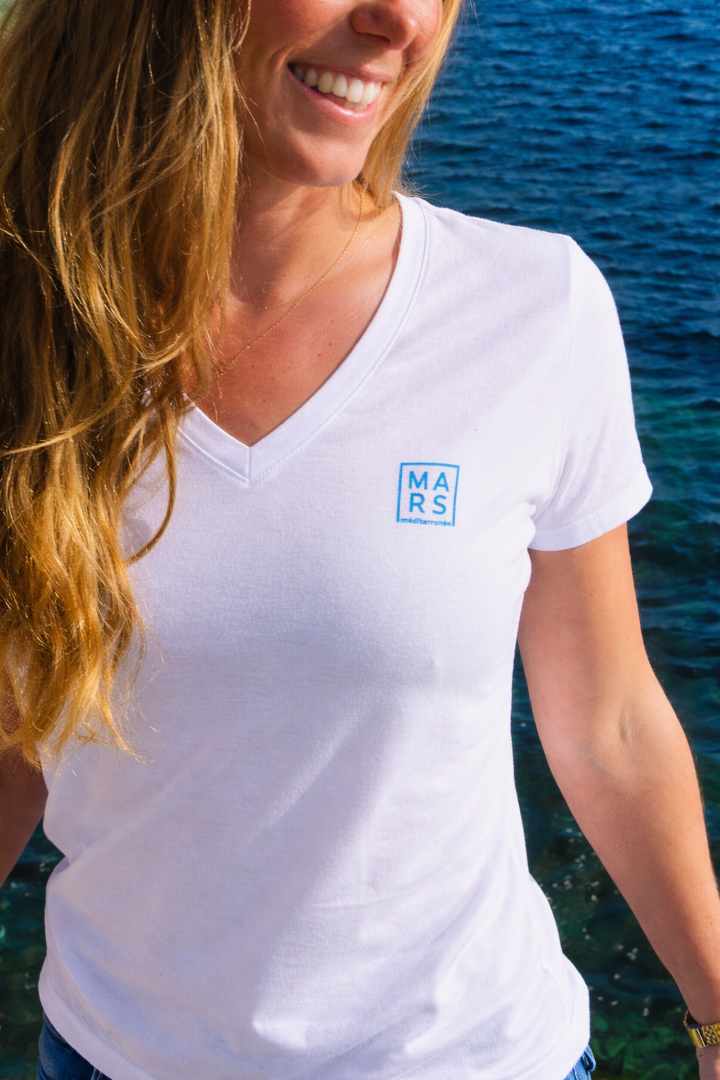Femme portant un t-shirt blanc avec logo MARS méditeranée