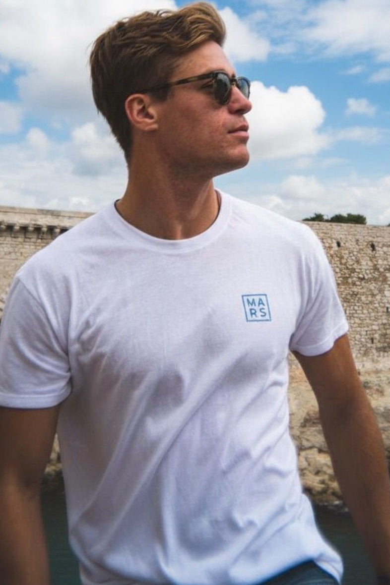 Un homme avec un t-shirt blanc et logo bleu sur la poitrine