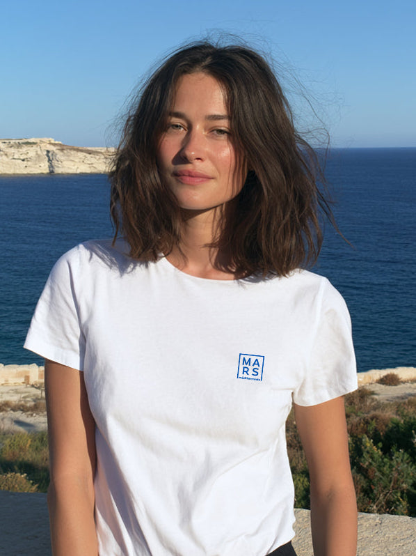 Une femme au bord de mer portant un tee-shirt avec un logo bleu
