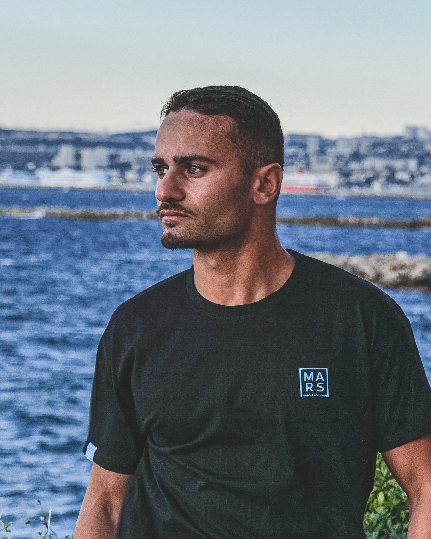 Homme portant un t-shirt noir avec logo MARS méditerranée