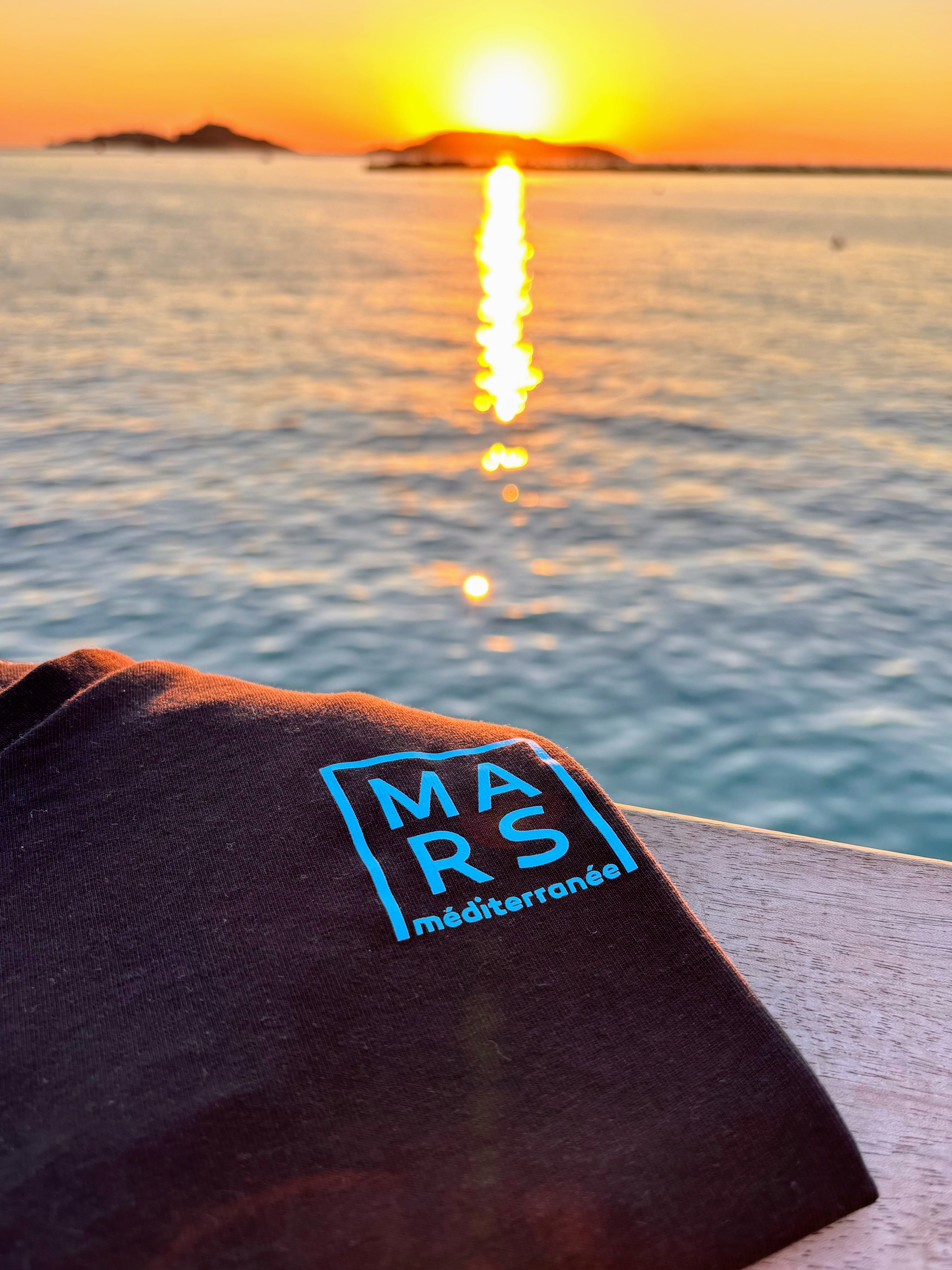 T-shirt noir avec mer et coucher de soleil en arrière-plan