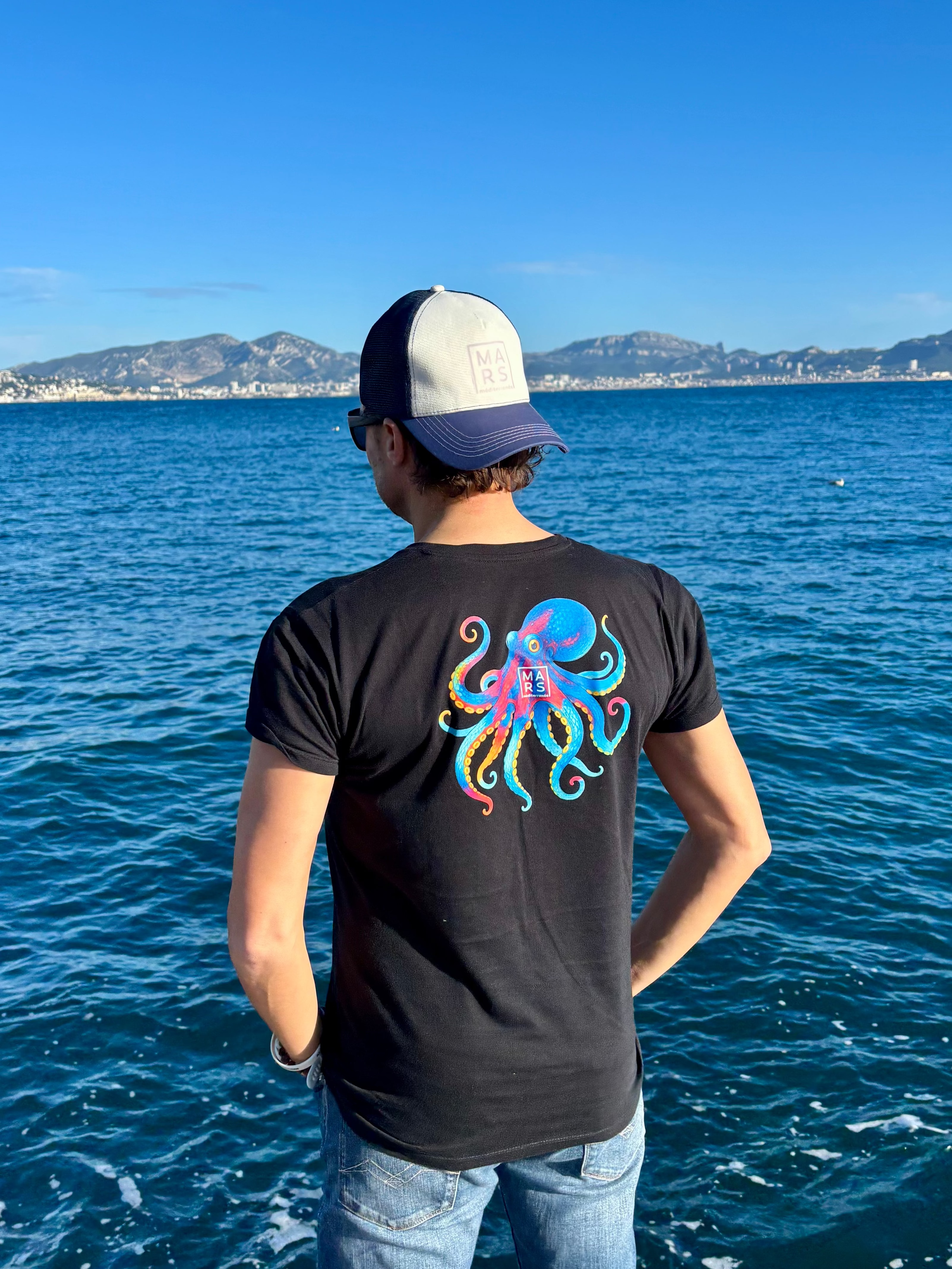 Homme portant un t-shirt noir avec un motif de poulpe géant
