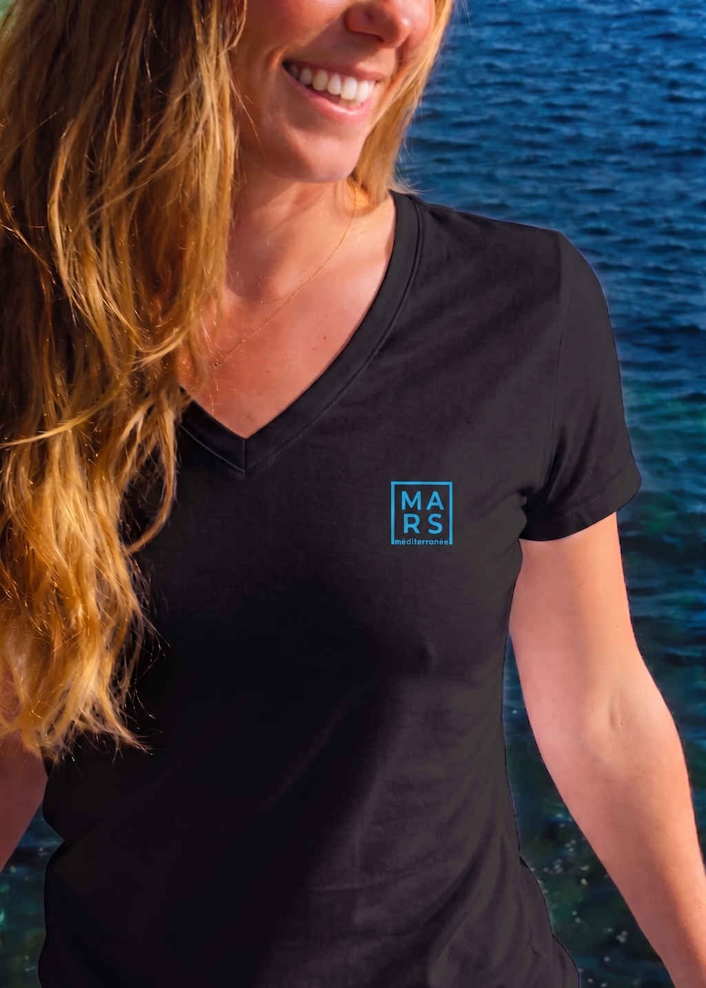 Femme portant un t-shirt noir avec un logo MARS méditerranée