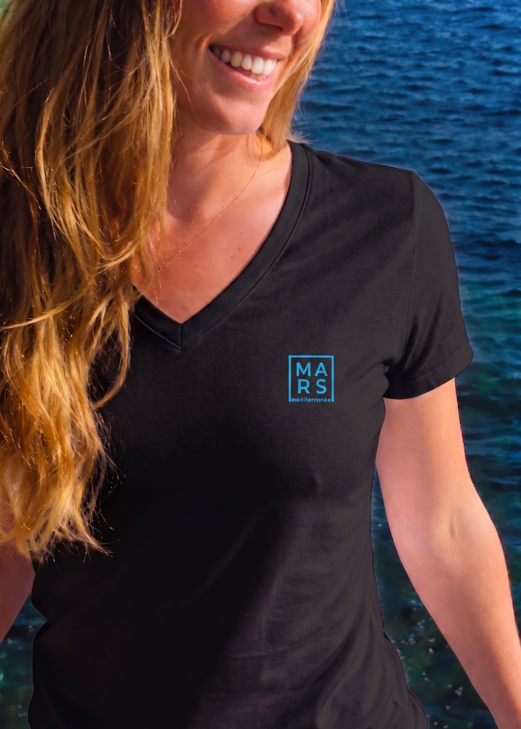 Femme portant un t-shirt noir avec un logo MARS méditerranée