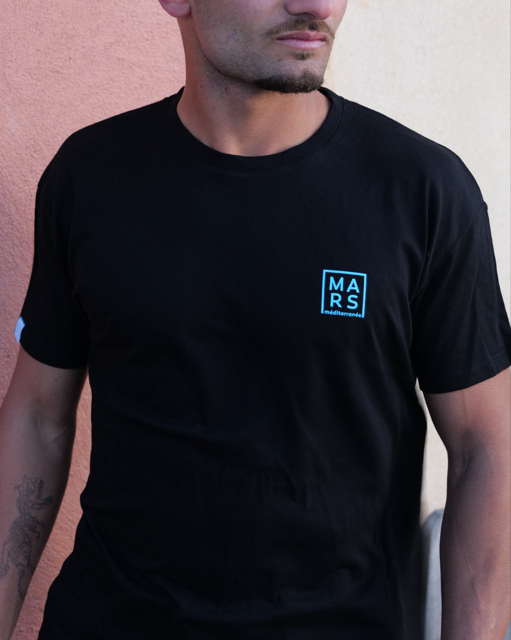 homme portant un t-shirt noir avec logo MARS méditeranée